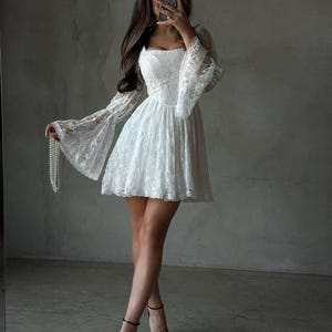 White lace women's dress - puffy sleeves, corset style top, flared skirt, hidden zipper on the side.Summer look, wedding outfit.